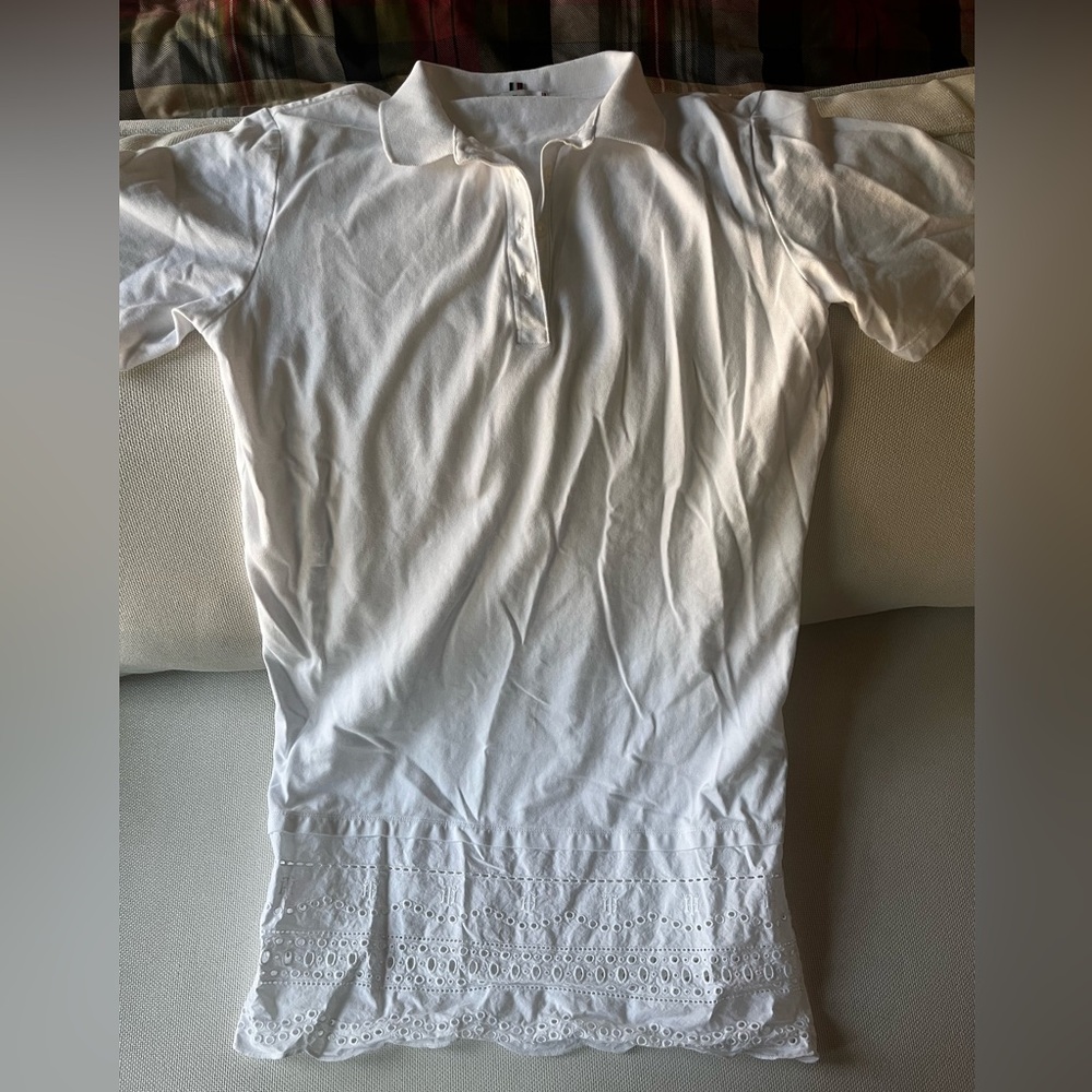 White Tommy Hilfiger polo dress with embroidered details at hem.